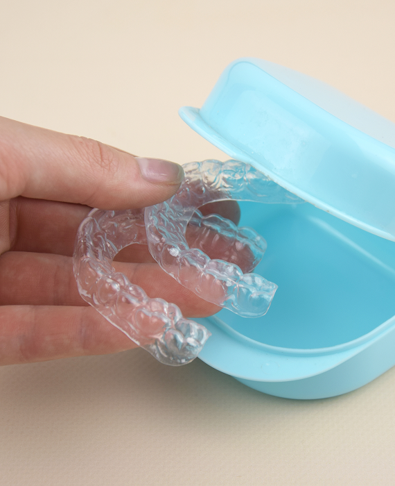Smiling woman looking into mirror brushing her teeth smoothly
